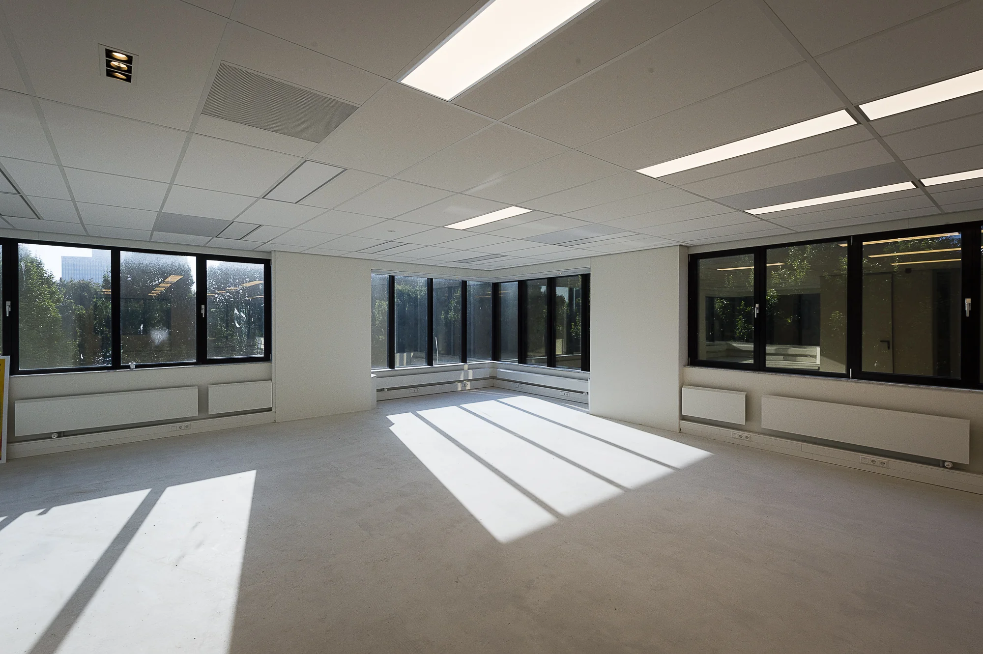 Lichte, lege kantoorruimte aan de Max Euwelaan met grote ramen en systeemplafond.